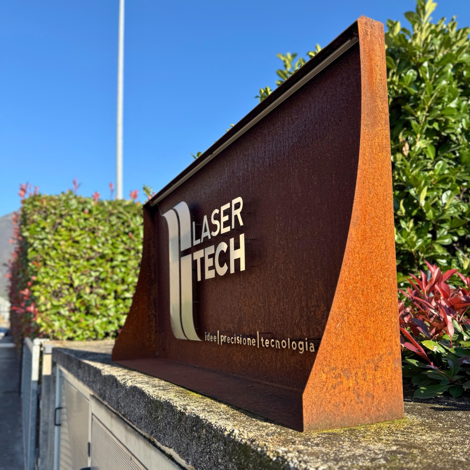 Insegna Laser Tech in acciaio corten all'esterno della sede di Schio